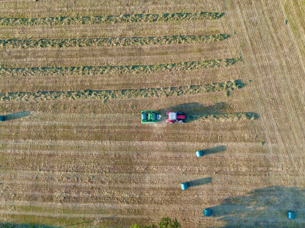 Aerial view of a tractor working across a harvested field