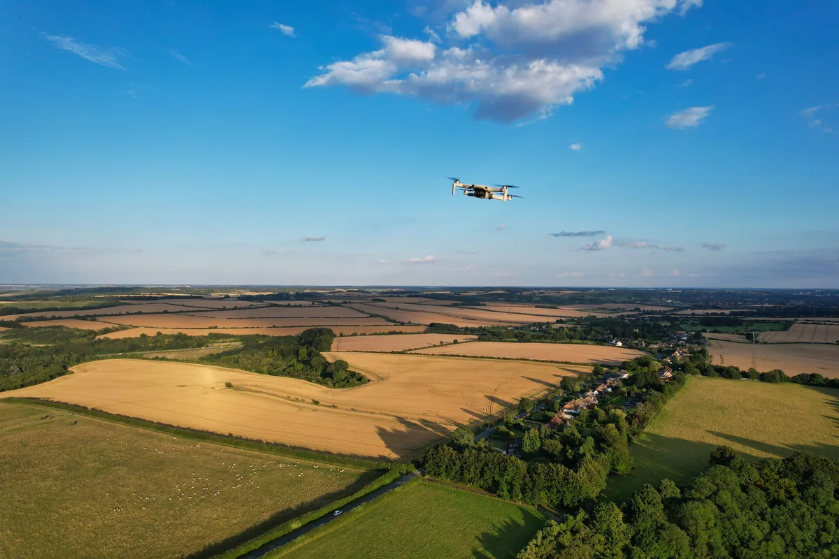 Drone flying over a rural agricultural landscape