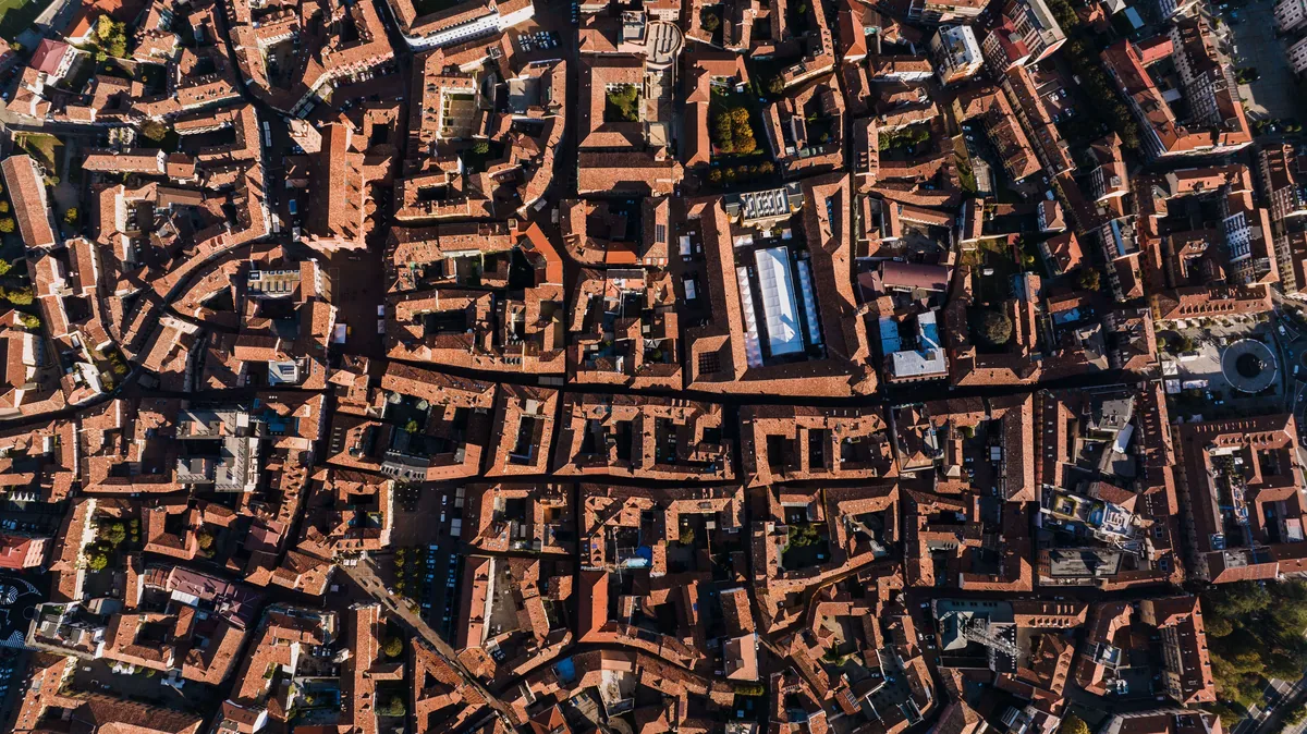 Aerial view of a dense urban area with geometric roof patterns