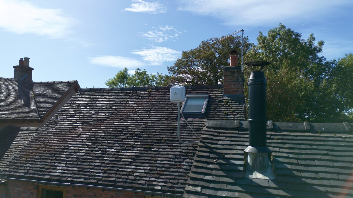 Directional 5G antenna installed on the roof beside the chimney